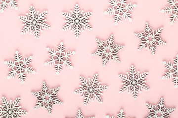 Christmas background. White snow decorations on a pink background.