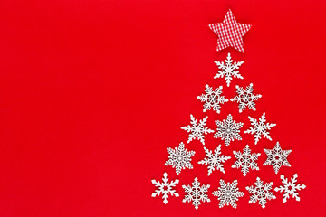 White snow flake decoration on red background. Flat lay, top view