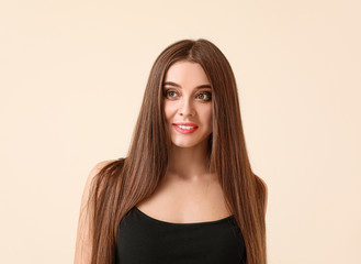 Beautiful woman with healthy long hair on light background