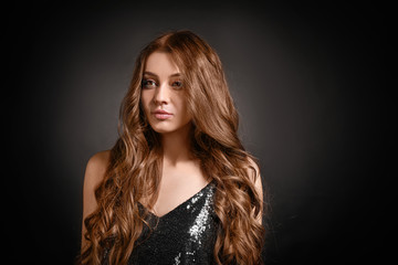 Naklejka premium Beautiful woman with curly hair on dark background