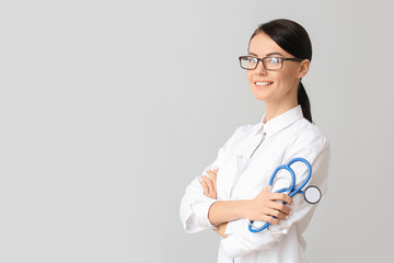 Female cardiologist on light background
