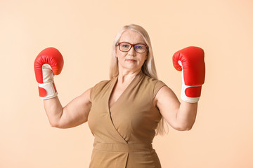 Woman in boxing gloves on color background. Concept of feminism