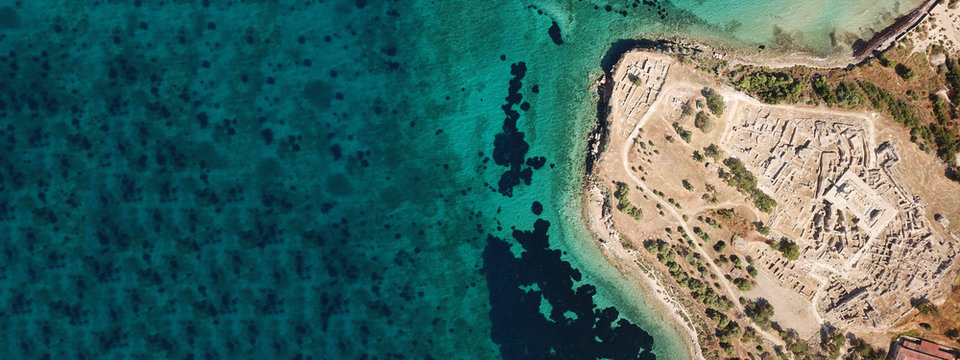 Aerial drone ultra wide top down photo of archaeological site of Temple of Apollo in island of Aegina, Greece