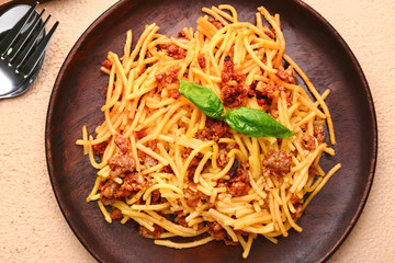 Plate with tasty pasta bolognese on color background