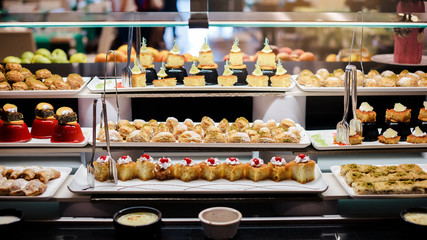 Delicious reception candy bar dessert table. Pieces of sweets cake dessert on a plate.