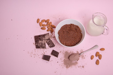 Crema de cacao vegana con leche de almendras en un fondo rosa pastel.