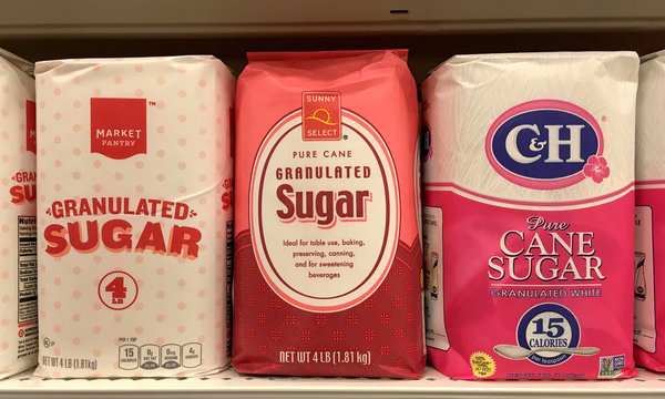 Alameda, CA - November 09, 2017: Grocery store shelf with bags of sugar. Generic and name brands. Sugar is used for baking, preserving, canning and for sweetening beverages among other things.