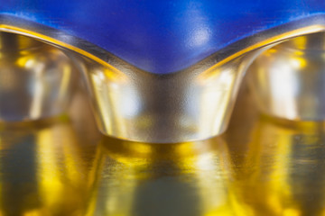 Abstract background of coffee capsules of gold color that are reflected on the surface. Concept abstraction, background