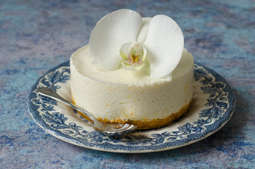 No baking cheesecake on a blue plate with orchid