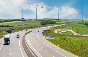 Cars on highway, wind turbines on background