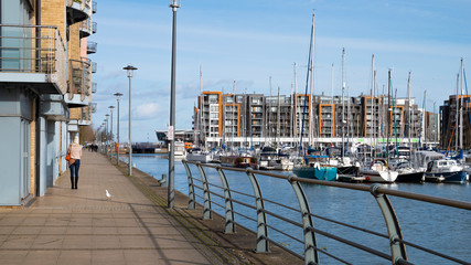 Portishead, England UK: A promenade alongside Portishead Quay Marina with yachts and flats on a...