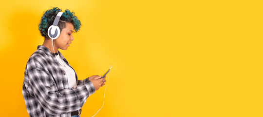 young brunette girl with mobile phone and headphones isolated on background