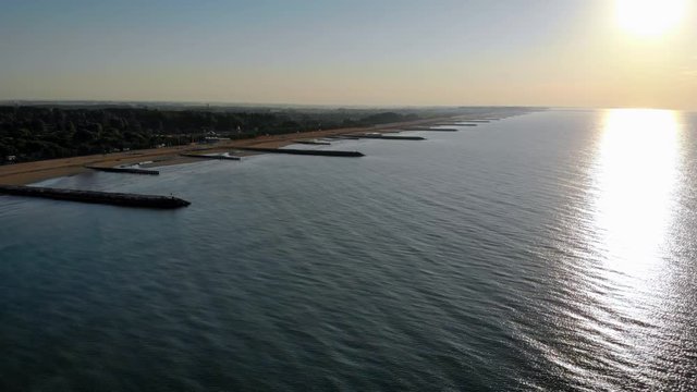 Aerial over the calm Adriatic sea reflecting the sun on a beautiful morning in Caorle, Italy