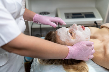 Obraz na płótnie Canvas Beautician makes a procedure for a girl to improve facial skin condition