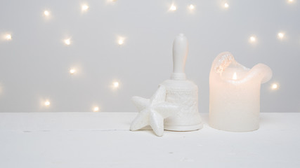 eine weiße Kerze und ein Weihnachtsstern vor weißem Hintergrund