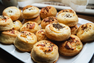 Homemade Cheese Scones with Caraway meridian fennel Persian cumin egg glazed baked buns in a plate fresh
