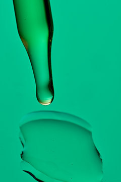 Studio shot of glass dropper with drop of CBD oil