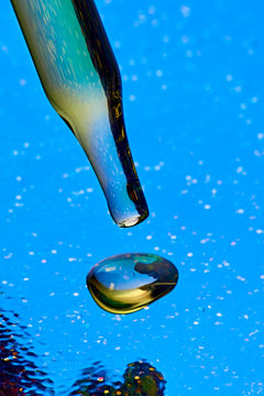 Studio shot of glass dropper with drop of CBD oil