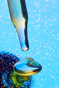 Studio shot of glass dropper with drop of CBD oil