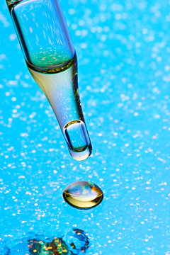 Studio shot of glass dropper with drop of CBD oil