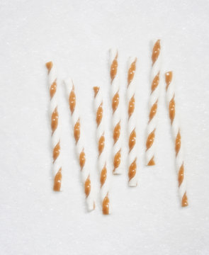 Overhead view of nougat candy canes on snow