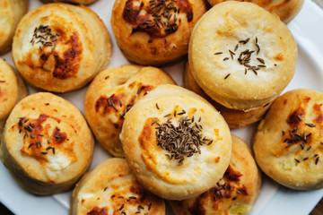 Homemade Cheese Scones with Caraway meridian fennel Persian cumin egg glazed baked buns in a plate fresh high angle