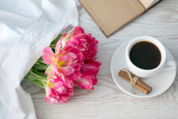 Mother's women's day concept. Greeting card with pink tulips and coffee on white background. 