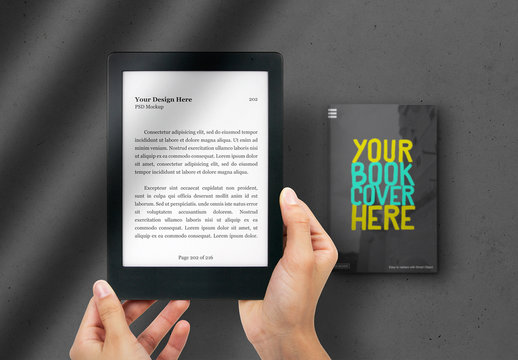 Hands Holding E-Reader with Book in the Background Mockup 