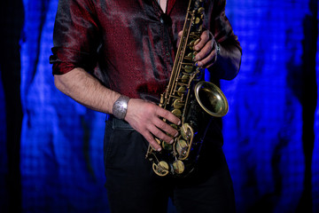 Fototapeta na wymiar Saxophone Player on blue blurred Background