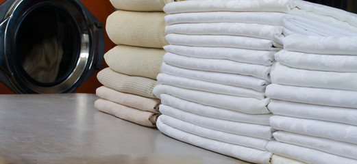 Stack of folded white cloths in an industrial laundry.