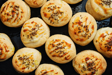 Homemade Cheese Scones with Caraway meridian fennel Persian cumin egg glazed baked buns in a black...