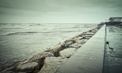 Fototapeta na wymiar Boardwalk on the Malvarrosa beach in Valencia on a rainy day