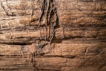 View inside the ancient cave with stone walls with additional lighting. Texture of a stone wall in a cave.