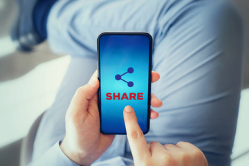 The man touching share icon on smart phone. Notification and social media concept.