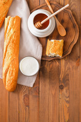 Sweet honey, milk and bread on table