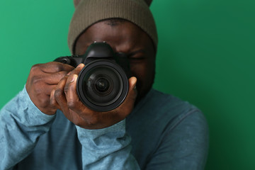 African-American photographer on color background