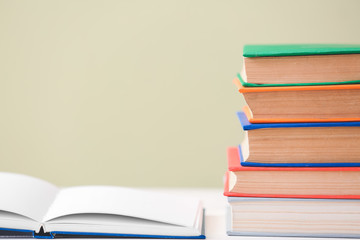 Many books on table against color background