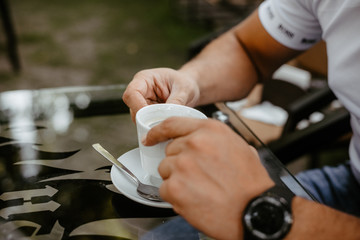 men's hands holding a cup of coffee