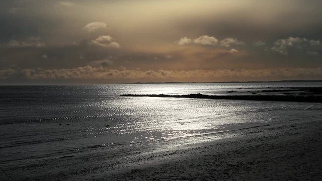 Dramatic morning sky over Irish beach shoreline, before storm approaches.