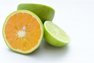Obraz na płótnie Canvas Tahiti lemons and whole and sliced oranges
