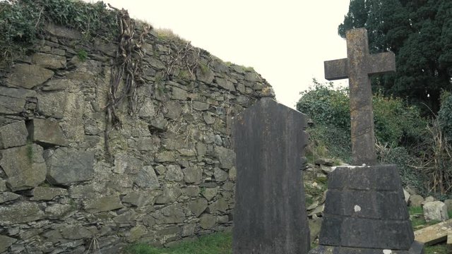 Crumbling stone church ruins in old Irish graveyard.