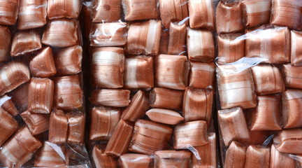 Tasty candies in plastic bag as a background.