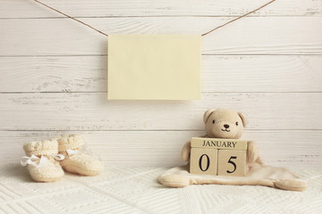 Calendar. January 5th. Day 5th of month. Teddy bear holding wood cube calendar with date of month and day. New born baby congratulation concept. Copy space.