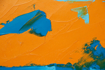 Textured background of oil paint in orange and blue tones, selective focus