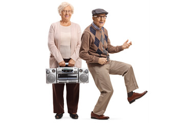 Senior woman holding a boombox radio and a senior man pretending to play a guitar