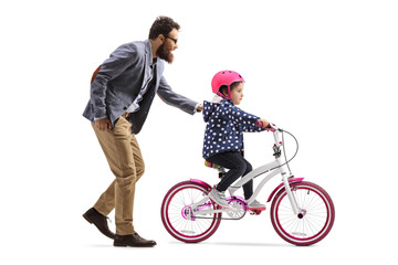 Obraz premium Father teaching daughter to ride a bicycle