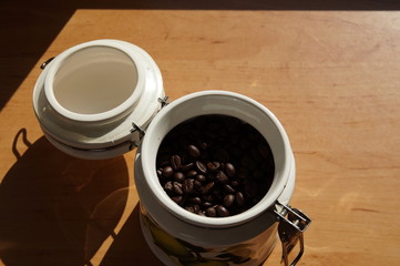 coffee beans in a ceramic container on a wooden table