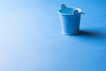 A metal garden bucket of blue color, miniature size. copy space. - obrazy, fototapety, plakaty
