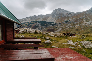 Tables on rustic wooden terace by the house with mountain view