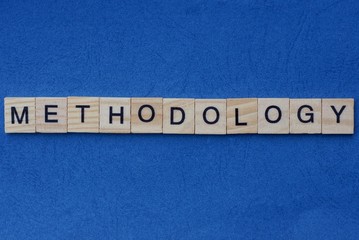 gray word methodology from small wooden letters on a blue table